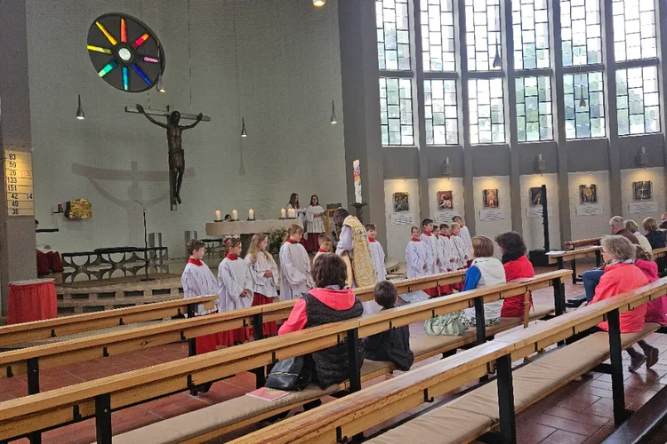 Ministranten in roten und weißen Gewändern beim Dienst am Altar